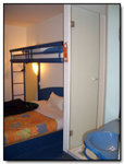 The room, enough to occupy 3 people. The shower with a glass door and the blue sink.