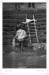 
A CHILD PICKING UP THE YELLOW CLOTH USED TO WRAP THE BODY
