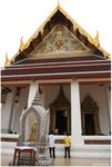 Two novice worshippers stand on the shiny floor in the temple.