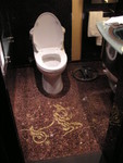 The washroom floor is laid with shiny mosaic tiles in a beautiful pattern