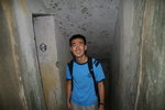 Philip stands outside the toilet in a bunker where the walls are decorated with only bullet holes. Imagine the terror the soldiers experienced in those days when merciless bullets from machine guns were rampaging human lives both inside and outside the facility. Behind him is a starcase leading down to a long dark tunnel