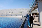 "Front" view of the Alexandria library, with the lake and the slanted roof..