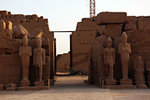Seven of the statues of pharaohs fromthis Cachette Court are still standing. Behing is the Seventh Pylon