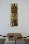 A funerary mosaic representing two characters: a deceased woman in an orant’s position depicted with her father and a banker portrayed at his office desk.