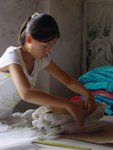 Costume factory in China - a teenage female worker tie up the embroidery pattern
